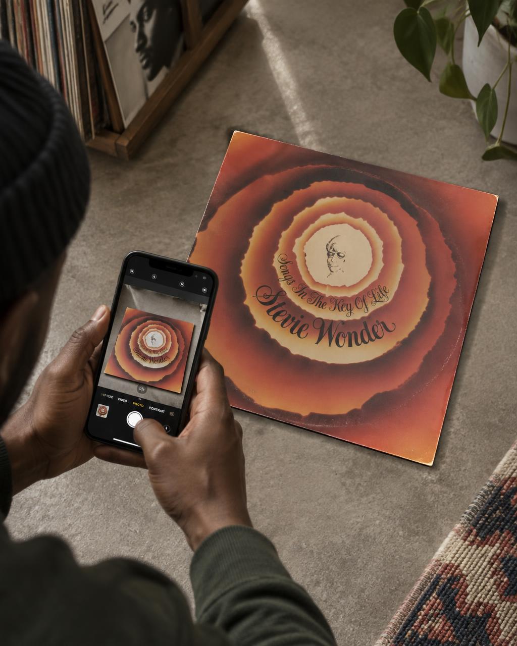 A record collector photographing a Stevie Wonder LP sleeve